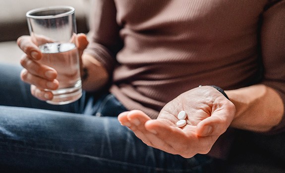 a woman taking two pills